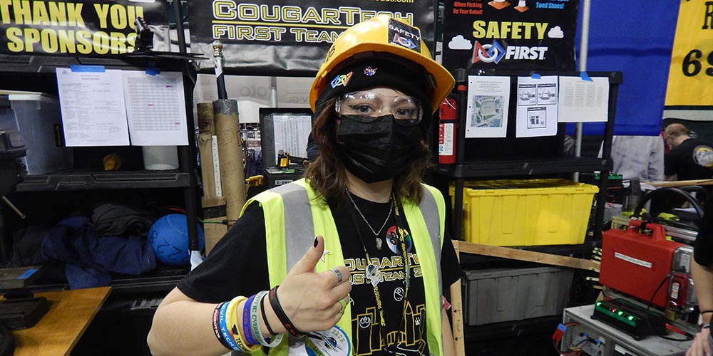 A picture of a student wearing a safety vest at a competition, they are part of the safety subteam.